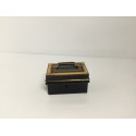 Lille sort pengekasse/sparebøsse med guld og røde dekorationer rundt om kassen